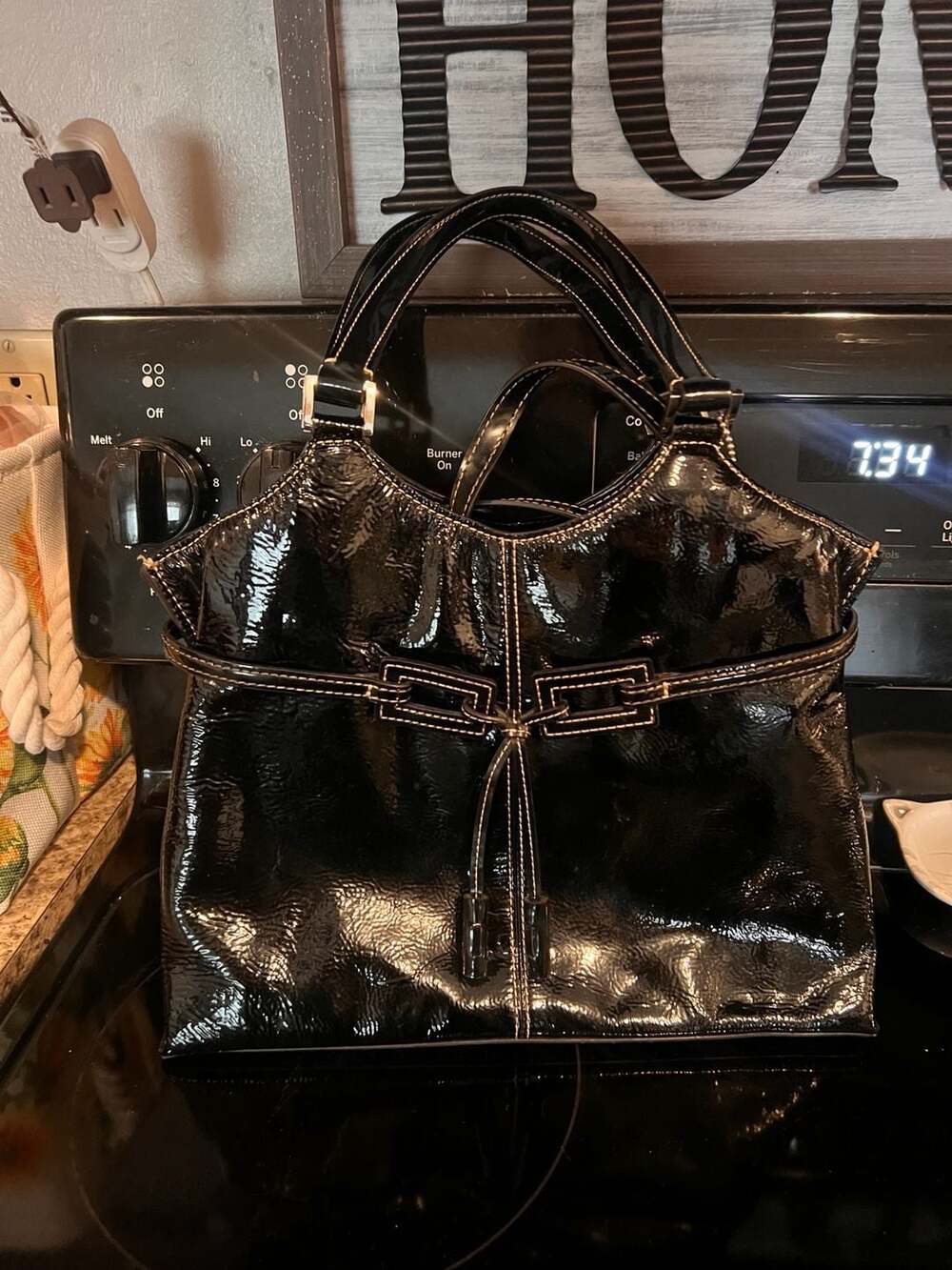 The Sak Black Patent Leather Shoulder Bag with Silver Hardware and Tassel Detail